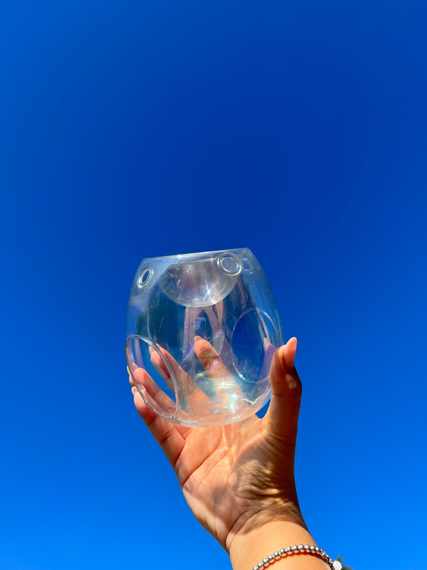 Photo of pearl glass wax melter holding in the sky